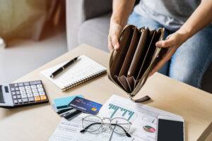 Chapter 13 Bankruptcy can help alleviate the situation in the image of an empty wallet and a stack of bills suggesting that it's time to get help with your finances.